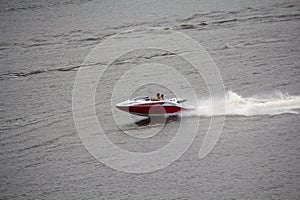 Two men are rapidly moving in a motor boat