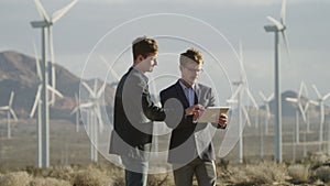 Two men reaching an agreement near the windmills