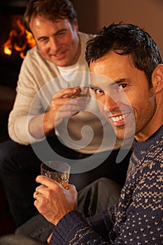 Two Men Relaxing Sitting On Sofa Drinking Whisky