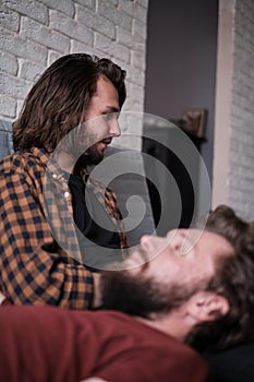 Two men relaxing together on the sofa