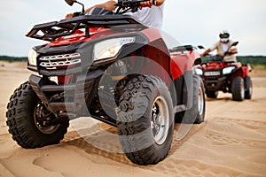 Two men ride on atv in desert