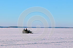 Two men riding on a snowmobile winter