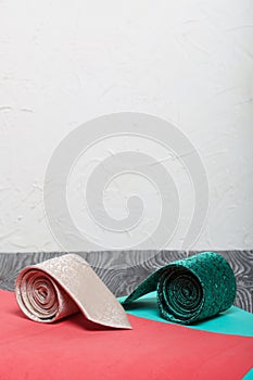 Two men`s ties in different colors and sizes. For father and son. Love and Togetherness Objects. On a coral and mint background