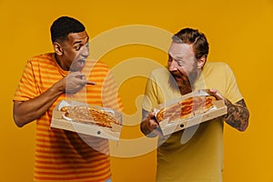 Two men screaming with thrill holding pizza while standing isolated