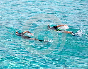 Two men in sea with equipment for snorkeling