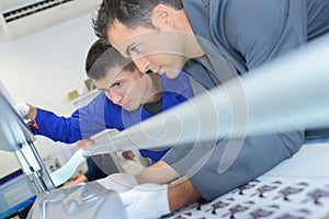 Two men setting up professional printing machine