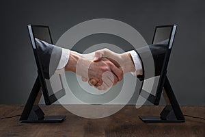 Two Men Shaking Hands Coming Out From Computer