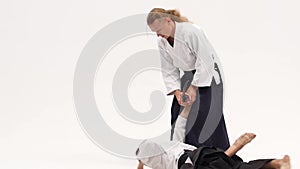 Two men showing aikido using katana. Isolated, white. Close up. Close up. Slow motion.