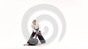 Two men showing aikido using katana. Isolated, white. Close up. Close up. Slow motion.