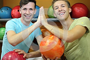 Two men sit near shelves in bowling club