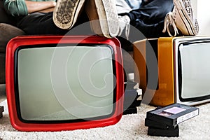 Two men sitting with two retro televisions