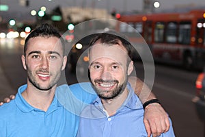 Two men smiling walking the city streets at night