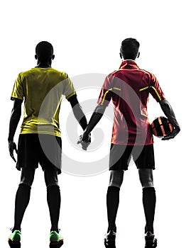 Two men soccer player standing hand in hand silhouette