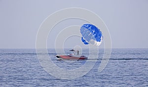 Two men on a speedboat fix a parachute after landing