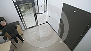 Two men stand in hall near coffee machine