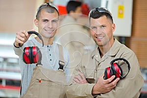 Two men standing in carpentry workshop