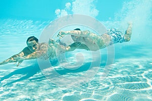 Two men swimming underwater