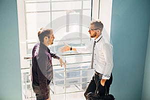 Two men talking in the lobby of the office