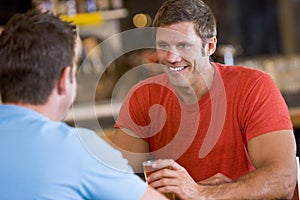 Two men talking over beer in a bar