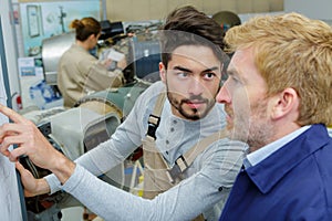 Two men talking in workshop