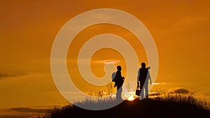 Two men tourists hikers silhouette go to the mountains sunset travel slow motion video. Traveler successful young men