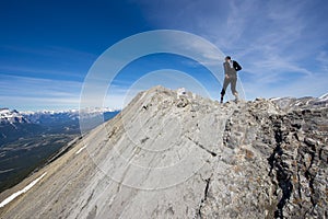 Two men trail running a steep ridge line in the mountains of canada