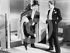 Two men in tuxedos with unconscious woman