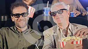 Two men watching 3D film at the movie theater