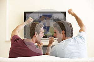 Two Men Watching Widescreen TV At Home photo