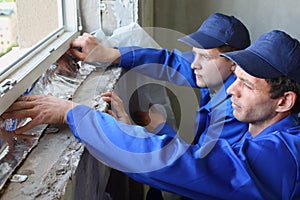 Two men in working clothes places the foiled