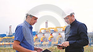Two men working engineers work at a gas plant producing gas oil. industry business teamwork concept. lifestyle Worker