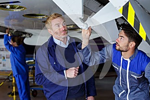 two men working under airplane