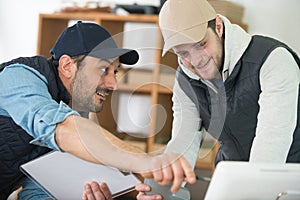 two men in workshop looking at computer screen