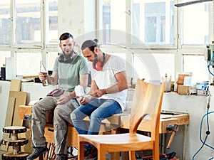 Two worker in a carpenters workshop taking a break