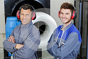 two men in workwear looking at camera