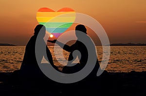 Two mens representing a homosexual couple , holding a heart with lgbt symbols