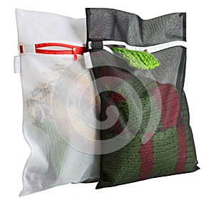 Two mesh bags filled with things, for washing in a washing machine, on a white background
