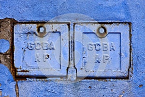 two metal box and a blue broken wall