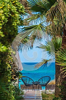 Two metal chairs on a wooden patio outside hotel in Greece