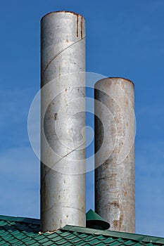 Two metal chimneys on a roof