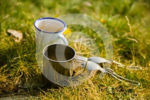 Two metal cups with tea on the mountain. Outdoors breakfast during the hike.