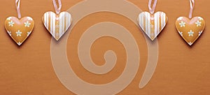 Two metal hearts in Peach Fuzz on a paper background