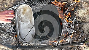 Two metallic cauldrons with boiling watet on fire ash in summer