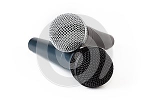 Two microphones laying on top of each other, pair of singing mics together, objects isolated on white background, cut out, singing