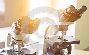 Two microscopes stand in the laboratory, close-up, sunlight