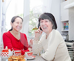 Two middle-aged girlfriends drinking tea