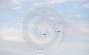 Two military long range bomber aircrafts flying in the cloudy sky