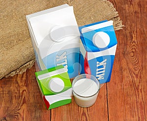 Milk carton different sizes and glass with various dairy produce photo