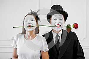 Two mime artists, love couple with rose in teeth