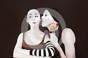 Two mimes in hats on black background